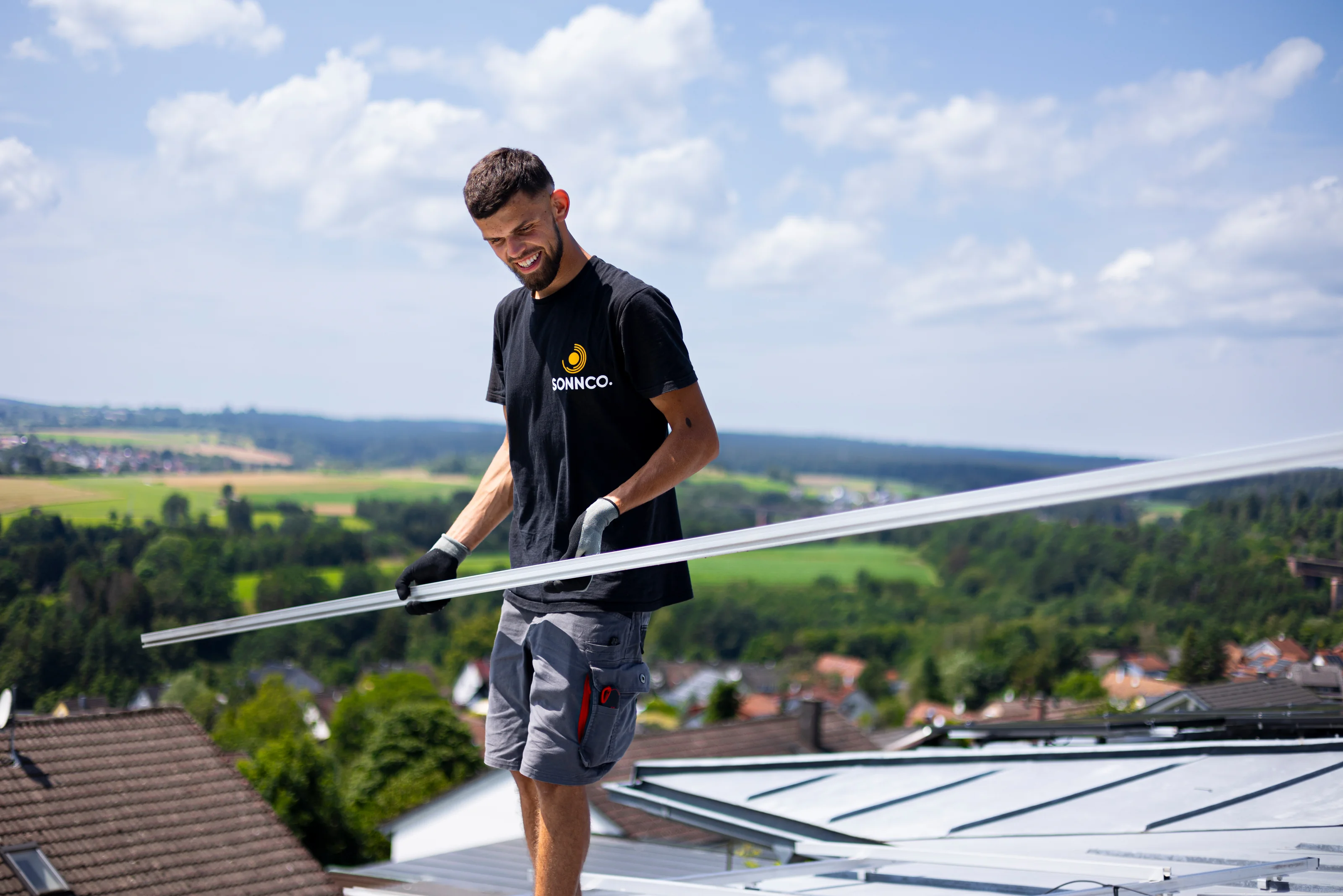 SONNCO Monteur auf dem Dach mit Blick über die Region