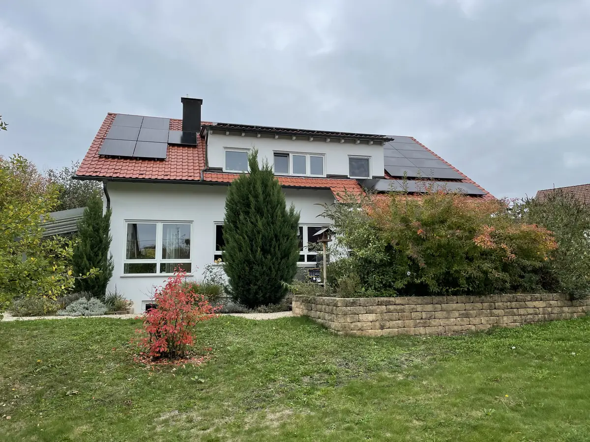 Haus mit PV-Anlage im grünen Garten