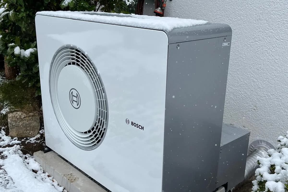 Bosch Wärmepumpe im Winter vor einem Einfamilienhaus