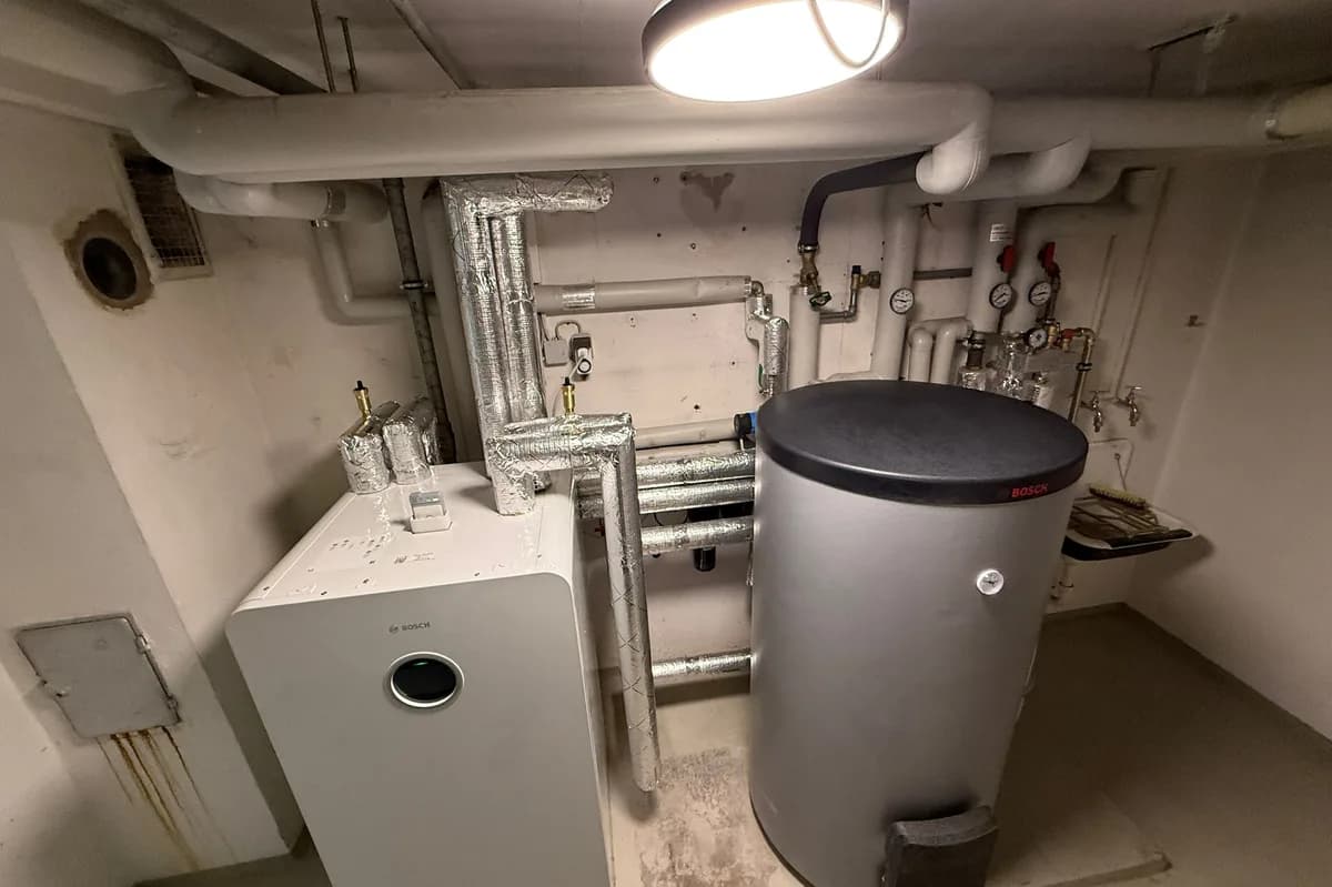 Heizungsraum mit Wärmepumpen-Innengerät und Speicher