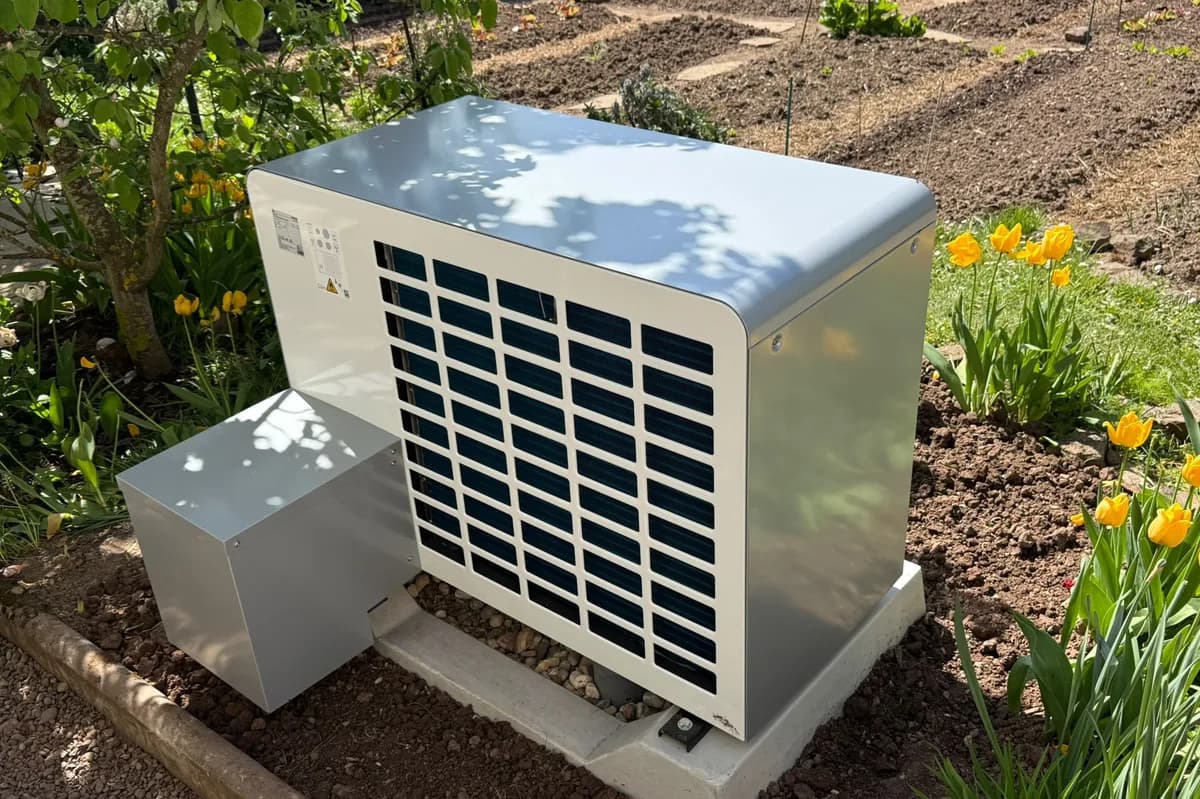 Wärmepumpe im Garten zwischen Tulpenbeeten